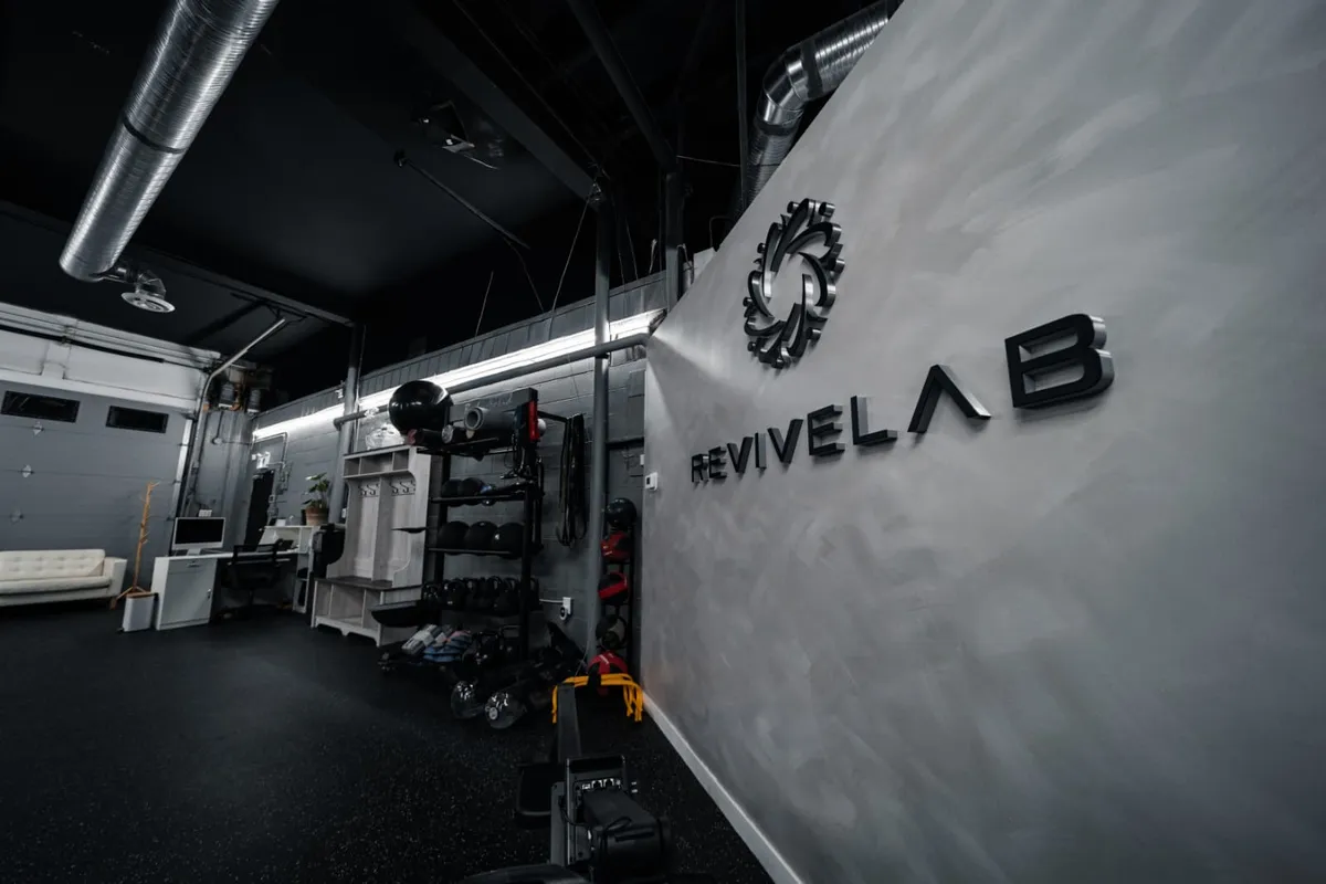 Inside REVIVELAB in Bridgeland, with the wall logo, training equipment and reception area